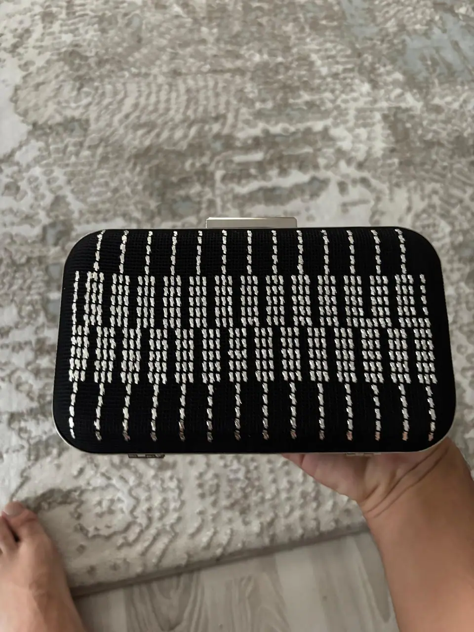 Siyah zemin üzerine beyaz dikey ilmeklerle işlenmiş clutch