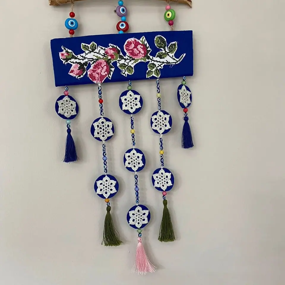 Gül kanaviçeli, yıldız madalyonlu ve püsküllü duvar süsü